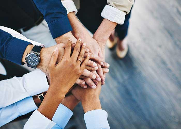 business people piling their hands