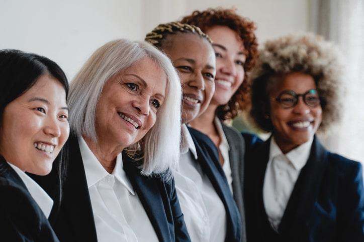 business women in suits pose for a photo