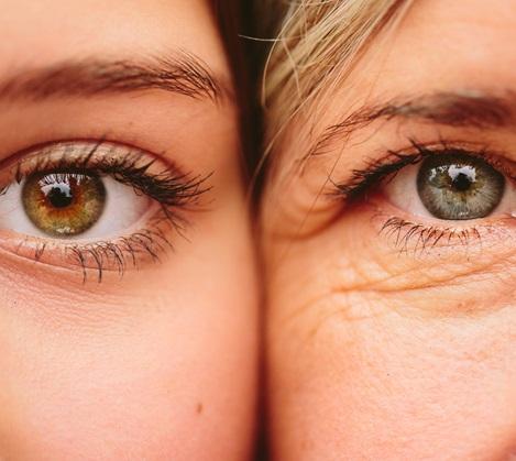 Two faces side by side with one eye showing on each face with them pushed up against each other.