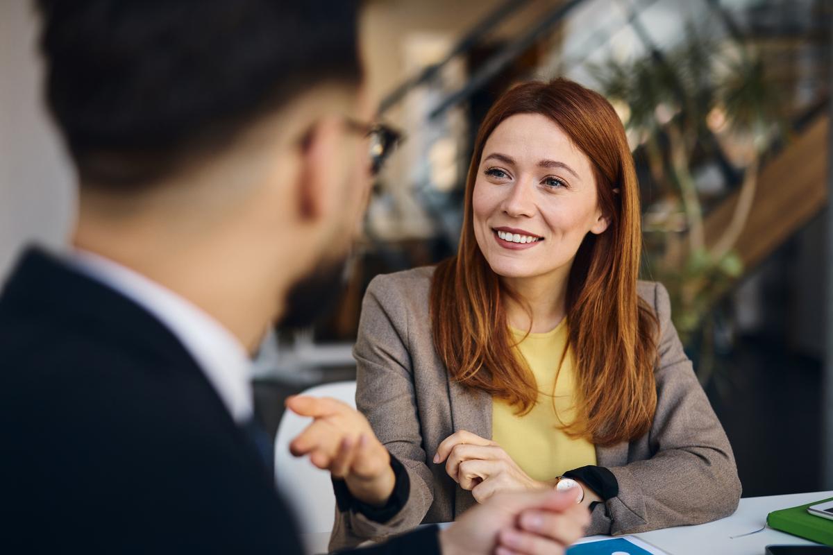 Businesswoman smiling and discussing with a businessman in the office