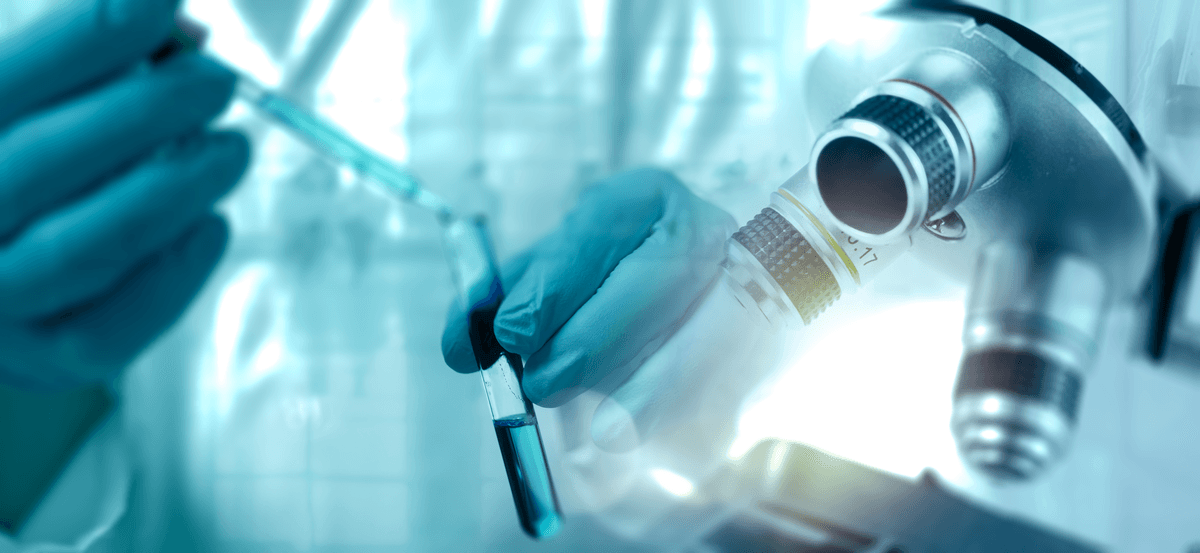 Time Compression Header Image of Gloved hand with test tube in a lab setting near a microscope.